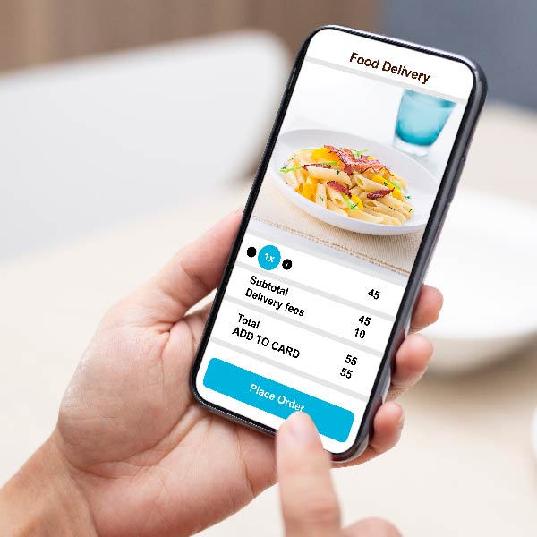Rankoje laikomas išmanusis telefonas su maisto užsakymo programėle ekrane, rodomas patiekalas ir užsakymo detalės.