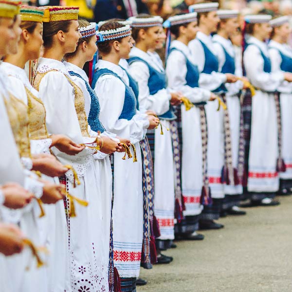 Merginos, vilkinčios tautinius drabužius.